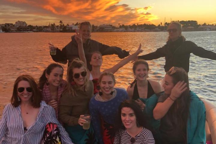 a group of people posing in front of a body of water