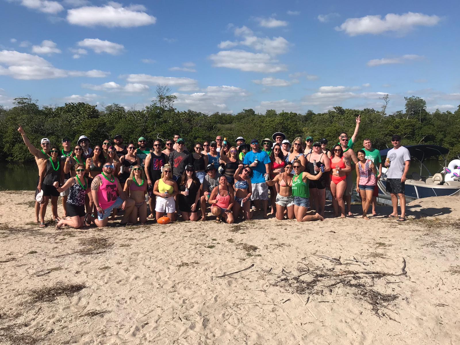 a group of people on a beach posing for the camera