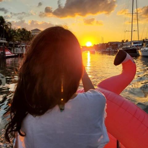 a person with long hair and a sunset in the background