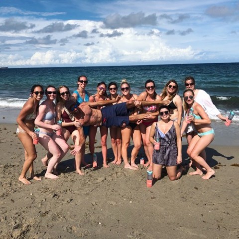 a group of people standing on top of a sandy beach