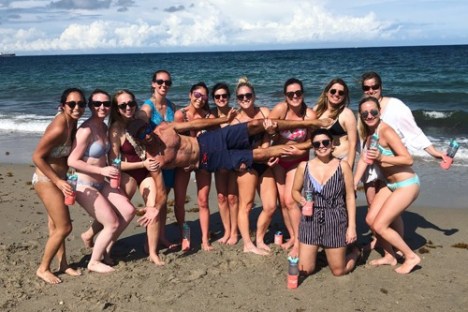 a group of people standing on top of a sandy beach