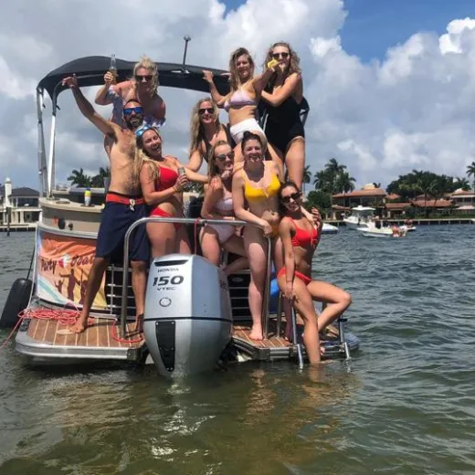 a group of people riding on the back of a boat in the water