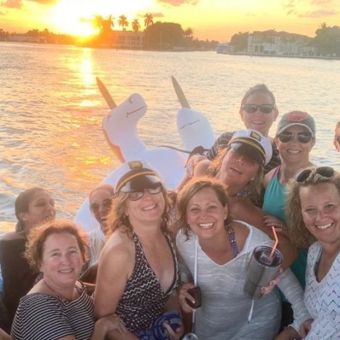 a group of people posing in front of a body of water