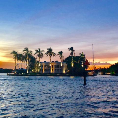 a sunset over a body of water with a city in the background