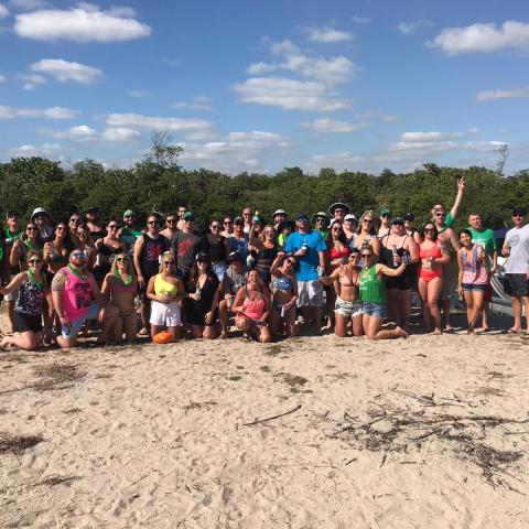 a group of people on a beach posing for the camera