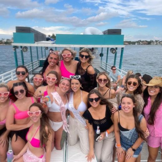 a group of people posing in front of a body of water